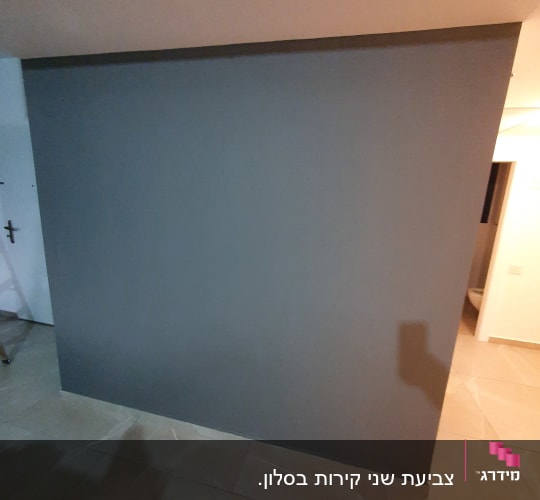 קיר צבוע בצבע אפור כהה על רצפת אריחים
